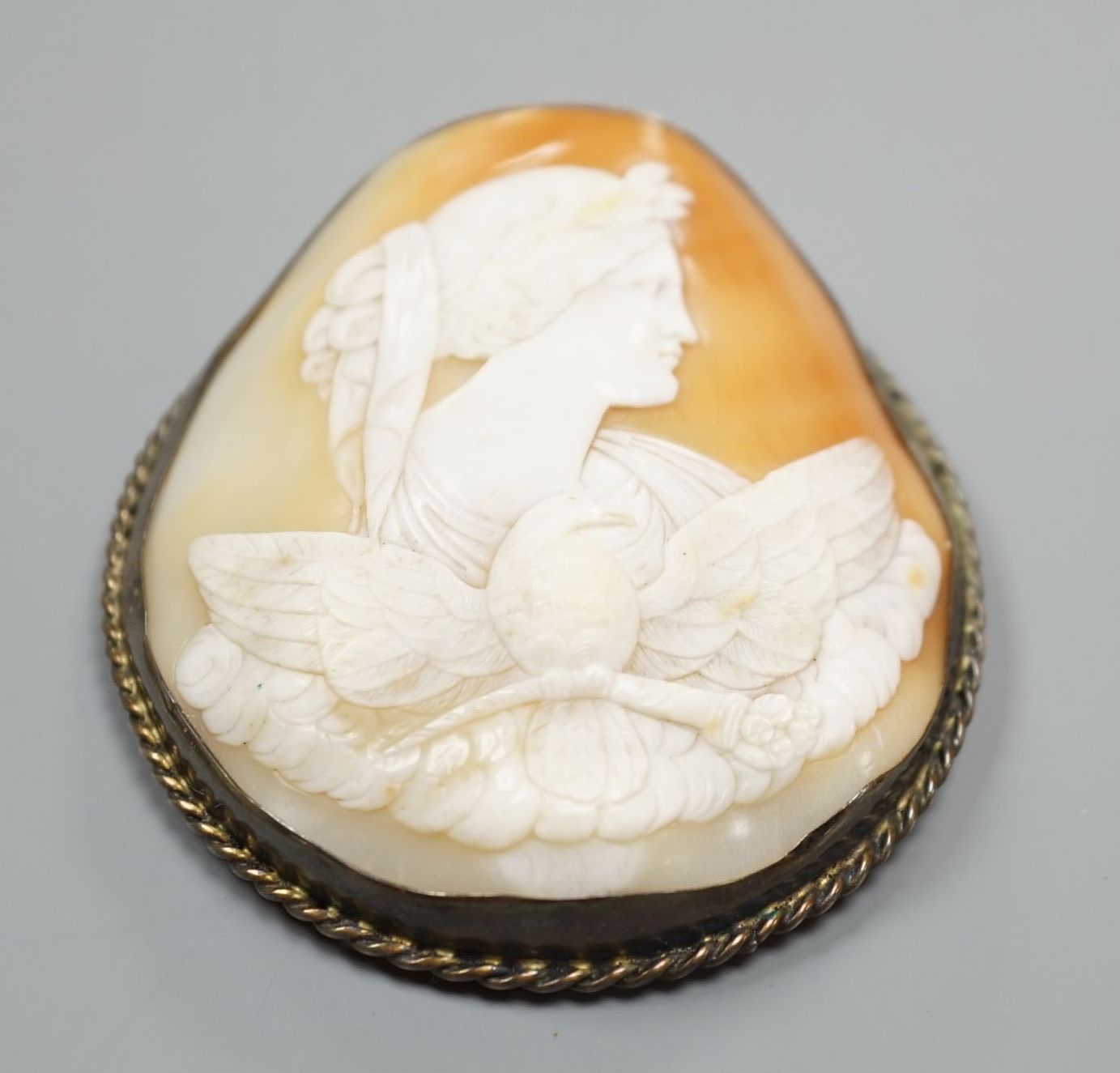 A large white metal mounted oval cameo shell brooch, carved with the Goddess Diana and eagle, 75mm.